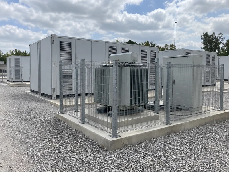 Fenced transformer and electrical cabinet beside battery energy storage containers